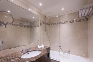 巴黎鲁尼沃圣日耳曼大酒店的浴室配有盥洗盆和带镜子的淋浴