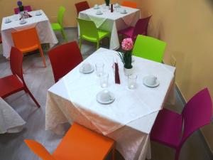 San Paolo di IesiAffittacamere Rooms Di Matteo的用餐室配有2张桌子和五颜六色的椅子