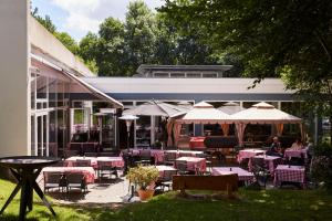 孔恩斯灵比费德利克斯达尔辛纳特酒店及会议中心的一个带桌椅和遮阳伞的户外庭院。