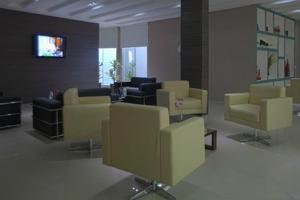 库亚巴斯卡拉旅游酒店的一间设有黄色椅子和平面电视的等候室