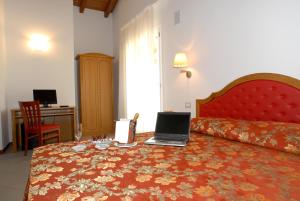 博洛尼亚维拉阿雷图斯酒店的酒店客房,配有一张带笔记本电脑的床