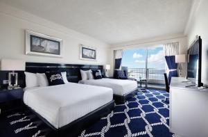 圣罗克Kensington Hotel Saipan的酒店客房设有两张床和电视。