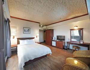 恒春古城垦丁假期渡假饭店的酒店客房,配有床和电视