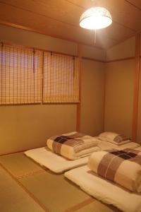 京都Love Kyoto 京缘馆的光线充足的客房内配有两张单人床。