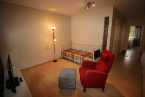 罗瓦涅米科斯基阿肯努斯公寓的客厅配有红色椅子和一张床