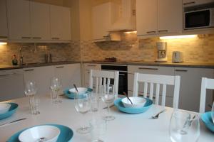 罗瓦涅米科斯基阿肯努斯公寓的厨房配有带盘子和玻璃杯的桌子