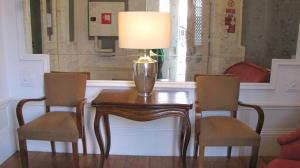 波尔图波尔图库尔豪斯旅馆的一张桌子,上面有两把椅子和一盏灯