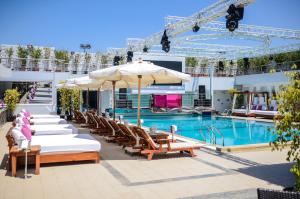 开罗Sun City Hotel - The Gabriel的酒店前方的游泳池配有椅子和遮阳伞