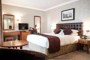 希灵登红狮酒店的酒店客房,配有床和电视