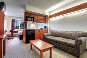 布里奇波特Microtel Inn & Suites by Wyndham Bridgeport的带沙发的客厅和带沙发床的房间