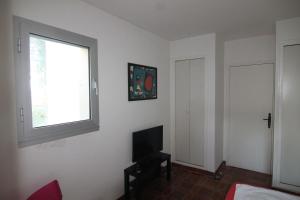 耶尔Presqu`ile de Giens的客厅配有电视、窗户和床。