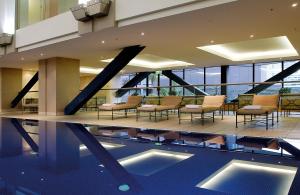 奥克兰奥克兰千禧大酒店的酒店大堂设有游泳池和椅子,大楼