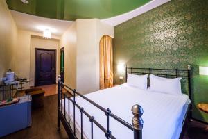 托木斯克卡利弗酒店的一间卧室设有一张床和绿色的墙壁