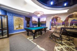 托木斯克卡利弗酒店的蓝色墙壁的房间里设有一张台球桌