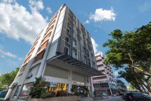 关丹Hotel Sentral Kuantan @ Riverview City Centre的街道边高大的白色建筑