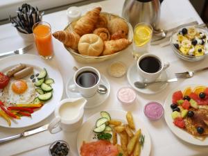 洛伊克巴德瓦力瑟洛伊克巴德阿尔卑斯温泉酒店的餐桌,带早餐食品盘和咖啡杯