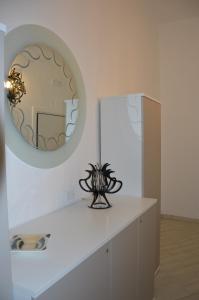 马萨夫拉Ancora Una Volta的一间设有白色柜台和圆镜子的房间