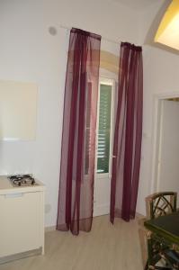 马萨夫拉Ancora Una Volta的厨房配有紫色窗帘和窗户