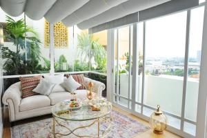 曼谷曼谷阿尔梅洛兹酒店 - 主要清真饭店的带沙发和玻璃桌的客厅