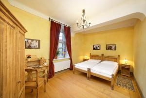 捷克克鲁姆洛夫赞美卡膳食旅馆 - 城堡公寓的一间卧室配有一张床、一张书桌和一个窗户。