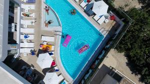 卡尔扎迈纳Agrelli Hotel & Suites的享有带人员和遮阳伞的游泳池的顶部景致