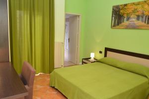 尼科洛西菲奥里迪拉瓦住宿加早餐旅馆的一间绿色卧室,配有一张床和墙上的绘画