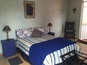 墨西哥城Maria Del Alma House的一间卧室配有一张带蓝色毯子的床