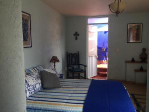 墨西哥城Maria Del Alma House的一间卧室配有一张带蓝色棉被的床