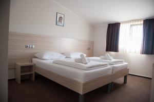 默主歌耶Hotel Glorija的一间卧室配有两张带白色床单和枕头的床。