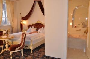 里约·迪·普斯特里亚安斯特兹坎德尔伯格酒店的卧室配有1张床、浴缸和桌子