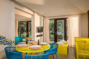 公主港巴拉望岛道夫酒店的一间设有黄色桌子和蓝色椅子的用餐室