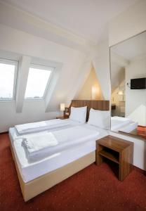维也纳Hahn Hotel Vienna的卧室配有一张白色的大床和一张桌子