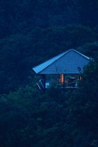 马迪凯里The IBNII - Eco Luxury Resort的山顶上带屋顶的房子