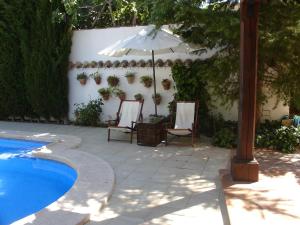 MotillejaCasa rural Villa Parchis的游泳池旁的遮阳伞和椅子