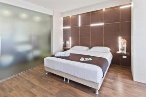 圣焦万尼因菲奥雷比夫拉Spa度假酒店的一间卧室配有一张大床和棕色床头板