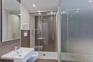 圣焦万尼因菲奥雷比夫拉Spa度假酒店的一间带玻璃淋浴和水槽的浴室