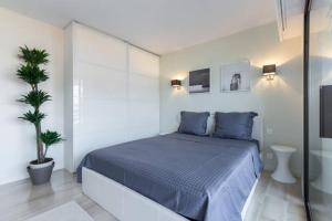 戛纳Appartement Residence Athena的一间卧室配有蓝色的床和盆栽植物