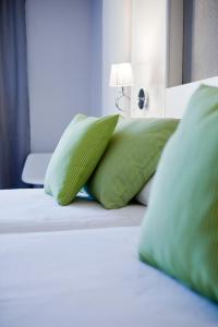 阿尔赫西拉斯米尔奥克塔维酒店的一张带绿色枕头的床