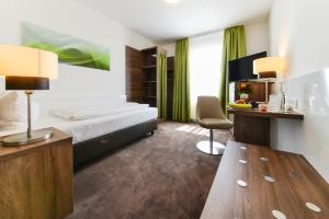 伦廷Hotel Günter的配有一张床和一张书桌的酒店客房