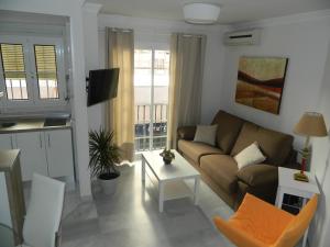 马拉加Apartamento Miramar的客厅配有沙发和桌子