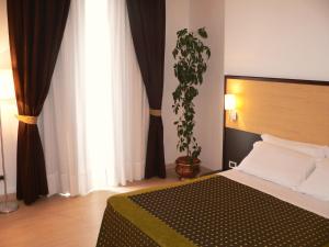 普尔萨诺伊尔格里洛酒店的一间卧室配有一张床和盆栽植物