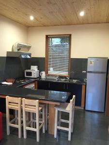普孔Loft Pucon的厨房配有冰箱和桌椅