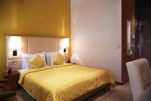奥帕提亚ASTORIA Hotel Opatija的酒店客房,配有一张黄色床罩床