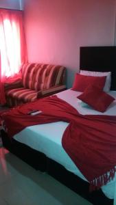 比勒陀利亚山谷住宿加早餐旅馆的一间卧室设有两张床和红色的墙壁