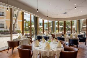 木洛希尼阿罕布拉精品酒店的餐厅设有白色的桌椅和窗户。