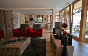 奥伯斯特多夫Landhaus Alpenflair Whg 310的客厅配有2把红色椅子和电视