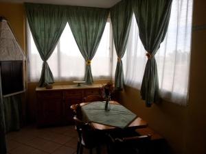 玛格丽塔萨沃亚Appartamento Angela的一间带桌子和2个窗户的用餐室