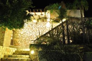 杰拉尼Gerani Private Villa的一座石头建筑,晚上有楼梯和灯光