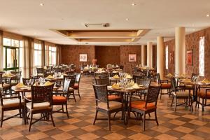普拉亚Pestana Tropico Ocean & City Hotel的一间在房间内配有桌椅的餐厅