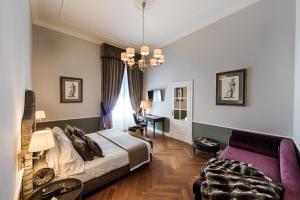 佛罗伦萨帕拉佐罗塞利切克尼酒店的一间卧室配有一张床、一张沙发和一张桌子